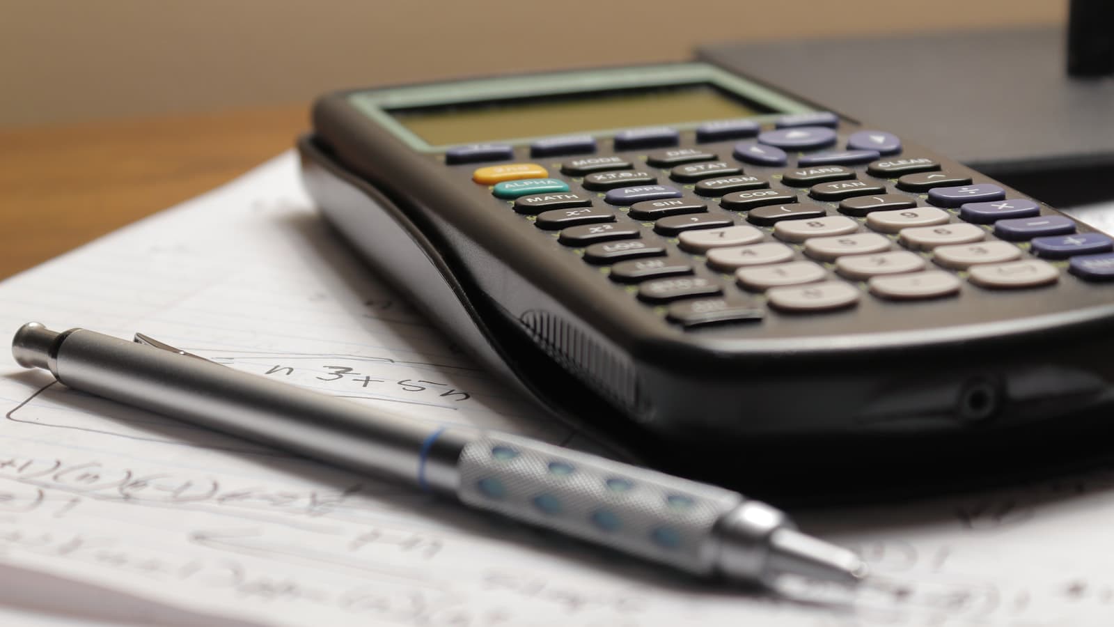 Calculator and pen resting on a printed quote